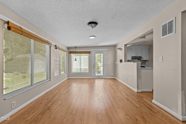 4404 Susan Dr, Raleigh, NC 27603 - unfurnished living room with light wood-type flooring and a textured ceiling