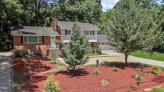 4404 Susan Dr, Raleigh, NC 27603 - tri-level home featuring driveway, a chimney, brick siding, an attached garage, and roof with shingles