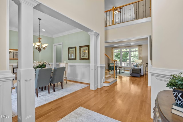 1028 Harpers Ridge Ct, Wake Forest, NC 27587 - foyer entrance with ornate columns, crown molding, stairway, a chandelier, and light wood finished floors