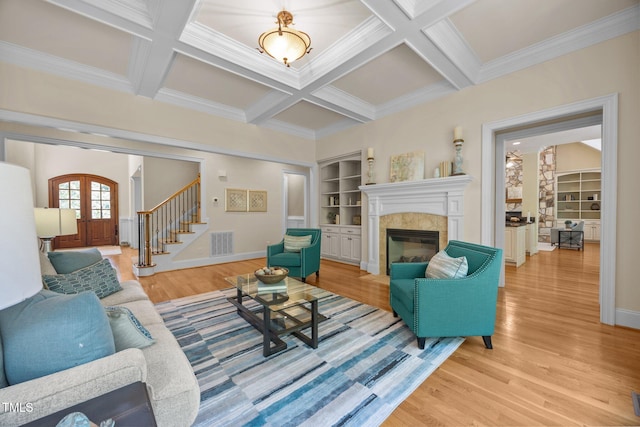 1028 Harpers Ridge Ct, Wake Forest, NC 27587 - living room with light wood-type flooring, a tile fireplace, stairs, crown molding, and beamed ceiling