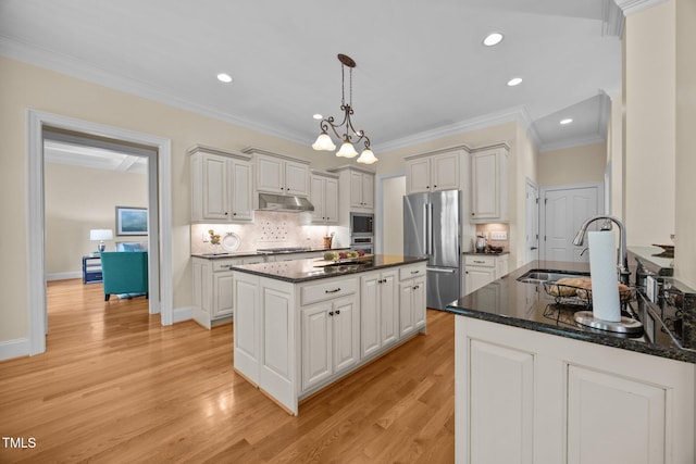 1028 Harpers Ridge Ct, Wake Forest, NC 27587 - kitchen with appliances with stainless steel finishes, under cabinet range hood, pendant lighting, tasteful backsplash, and light wood finished floors