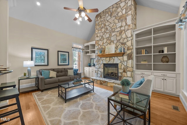 1028 Harpers Ridge Ct, Wake Forest, NC 27587 - living area with ceiling fan, light wood-type flooring, high vaulted ceiling, a stone fireplace, and built in shelves