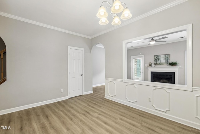 212 Cross Keys Ct, Cary, NC 27511 - unfurnished living room featuring arched walkways, wood finished floors, ornamental molding, a fireplace, and ceiling fan