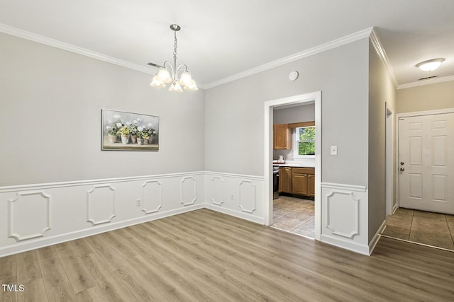 212 Cross Keys Ct, Cary, NC 27511 - unfurnished dining area featuring ornamental molding, light wood-style flooring, a chandelier, and a wainscoted wall
