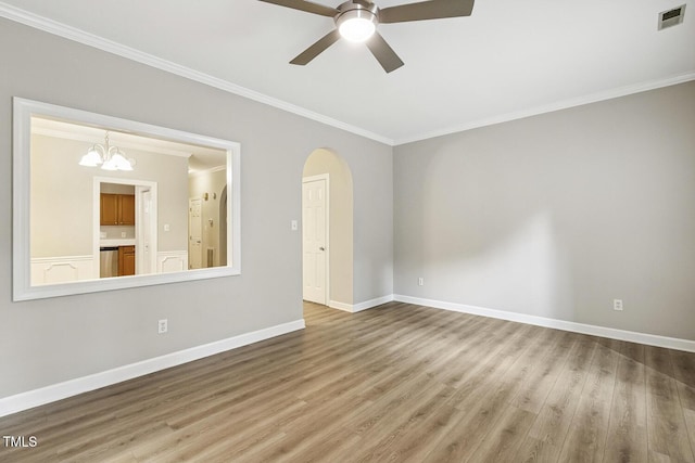 212 Cross Keys Ct, Cary, NC 27511 - spare room with a ceiling fan, crown molding, wood finished floors, a chandelier, and arched walkways