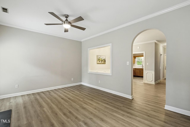 212 Cross Keys Ct, Cary, NC 27511 - empty room with crown molding, ceiling fan, arched walkways, and wood finished floors