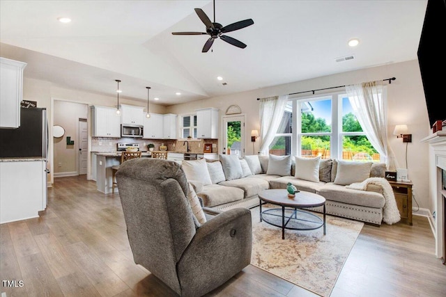 282 Brodie Rose Landing Way, Smithfield, NC 27577 - living room with ceiling fan, light wood-style floors, lofted ceiling, a fireplace, and recessed lighting