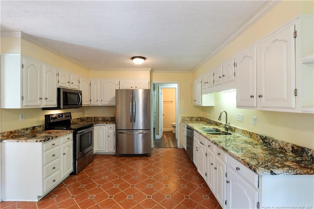 1612 Hennessy Pl, Fayetteville, NC 28303 - kitchen featuring appliances with stainless steel finishes, white cabinetry, dark stone countertops, ornamental molding, and a textured ceiling