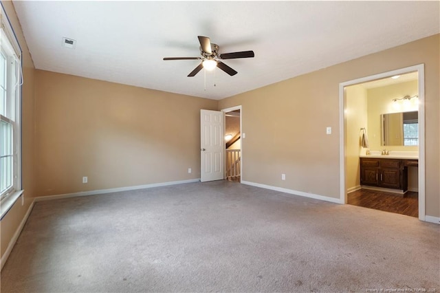 1612 Hennessy Pl, Fayetteville, NC 28303 - unfurnished bedroom with carpet flooring, multiple windows, connected bathroom, and a ceiling fan