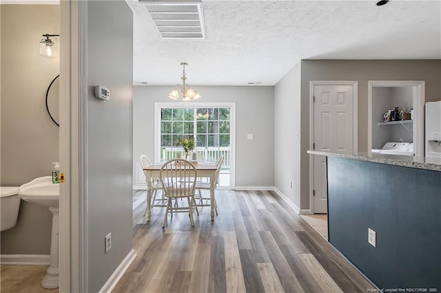 69 Ribbon Oak Ct, Sanford, NC 27332 - dining space featuring light wood-type flooring, a chandelier, and a textured ceiling