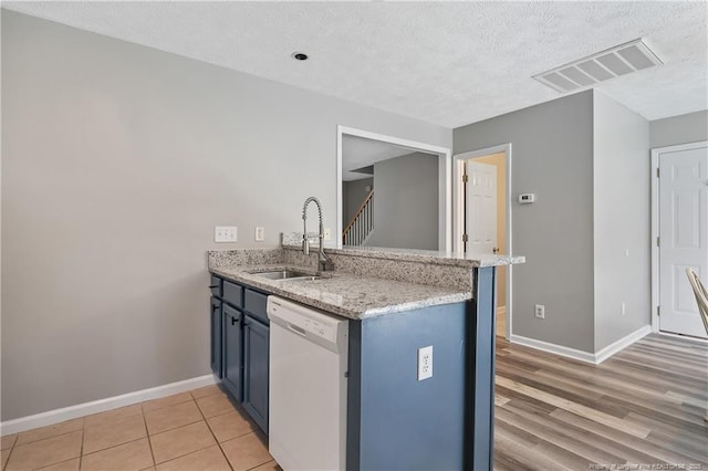 69 Ribbon Oak Ct, Sanford, NC 27332 - kitchen featuring dishwasher, a textured ceiling, a peninsula, light stone countertops, and blue cabinets