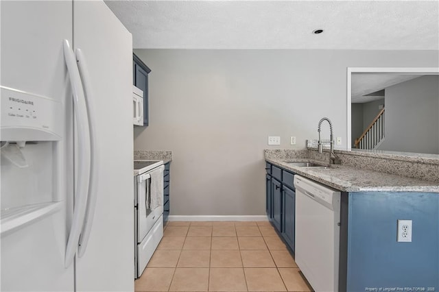 69 Ribbon Oak Ct, Sanford, NC 27332 - kitchen featuring white appliances, light tile patterned floors, light stone counters, blue cabinetry, and a textured ceiling