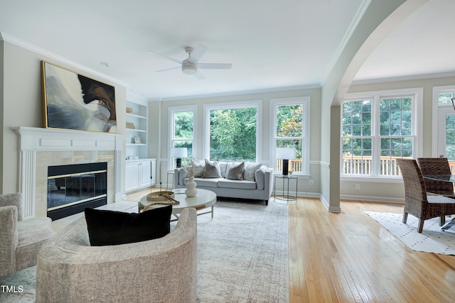 500 Walcott Way, Cary, NC 27519 - living area featuring a ceiling fan, ornamental molding, wood-type flooring, a fireplace, and arched walkways
