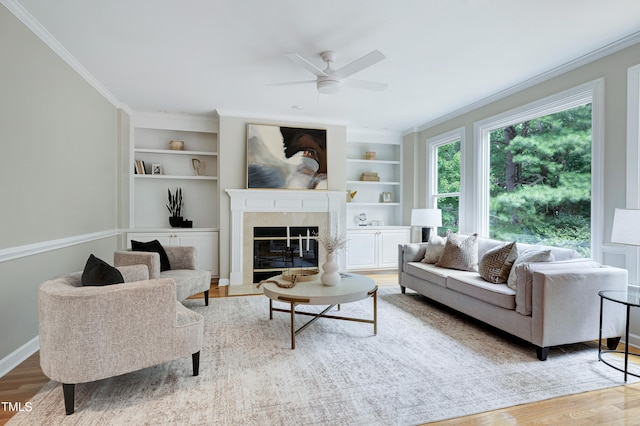 500 Walcott Way, Cary, NC 27519 - living room featuring a ceiling fan, built in features, wood finished floors, ornamental molding, and a fireplace with flush hearth