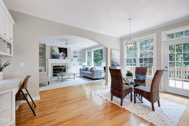 500 Walcott Way, Cary, NC 27519 - dining room featuring arched walkways, crown molding, healthy amount of natural light, a chandelier, and light wood finished floors