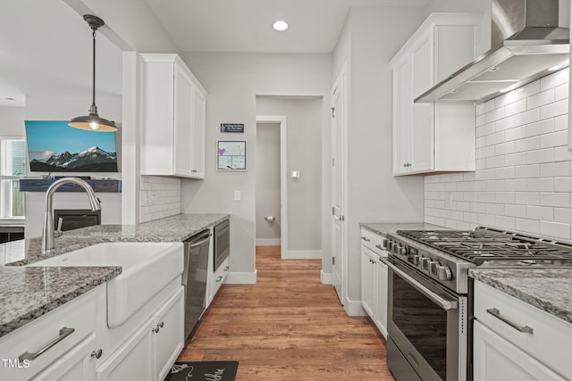 1006 Whistler St, Durham, NC 27713 - kitchen featuring stainless steel appliances, wall chimney exhaust hood, white cabinets, decorative backsplash, and recessed lighting