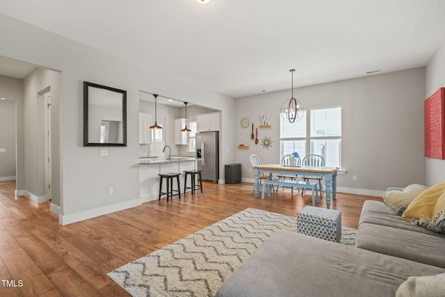 1006 Whistler St, Durham, NC 27713 - living room with light wood-style floors and a chandelier