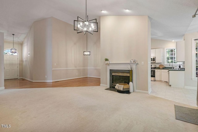 125 Chimney Rise Dr, Cary, NC 27511 - unfurnished living room featuring light carpet, a chandelier, and a fireplace with flush hearth