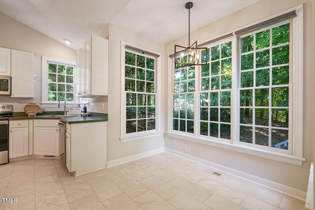 125 Chimney Rise Dr, Cary, NC 27511 - kitchen featuring stainless steel appliances, dark countertops, pendant lighting, a chandelier, and lofted ceiling