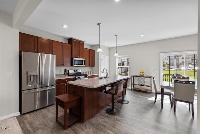 333 Amber Acorn Ave, Raleigh, NC 27603 - kitchen with stainless steel appliances, dark wood-type flooring, a center island with sink, recessed lighting, and a breakfast bar