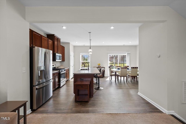 333 Amber Acorn Ave, Raleigh, NC 27603 - kitchen featuring appliances with stainless steel finishes, an island with sink, a breakfast bar area, pendant lighting, and recessed lighting