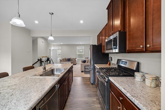 333 Amber Acorn Ave, Raleigh, NC 27603 - kitchen with stainless steel appliances, dark wood finished floors, open floor plan, hanging light fixtures, and light countertops