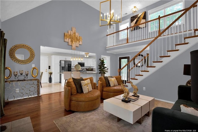 4010 Arcadia Ct, Fayetteville, NC 28311 - living room with high vaulted ceiling, stairway, light wood-style floors, and a chandelier