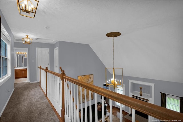 4010 Arcadia Ct, Fayetteville, NC 28311 - hallway featuring a chandelier, plenty of natural light, an upstairs landing, a textured ceiling, and carpet flooring