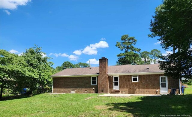 1519 Palmer Dr, Fayetteville, NC 28303 - rear view of house featuring entry steps, a chimney, brick siding, and a lawn