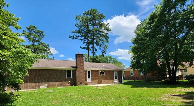 1519 Palmer Dr, Fayetteville, NC 28303 - rear view of house featuring entry steps, a chimney, a patio area, and brick siding