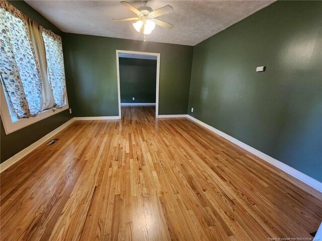 1519 Palmer Dr, Fayetteville, NC 28303 - spare room with wood finished floors, ceiling fan, and a textured ceiling
