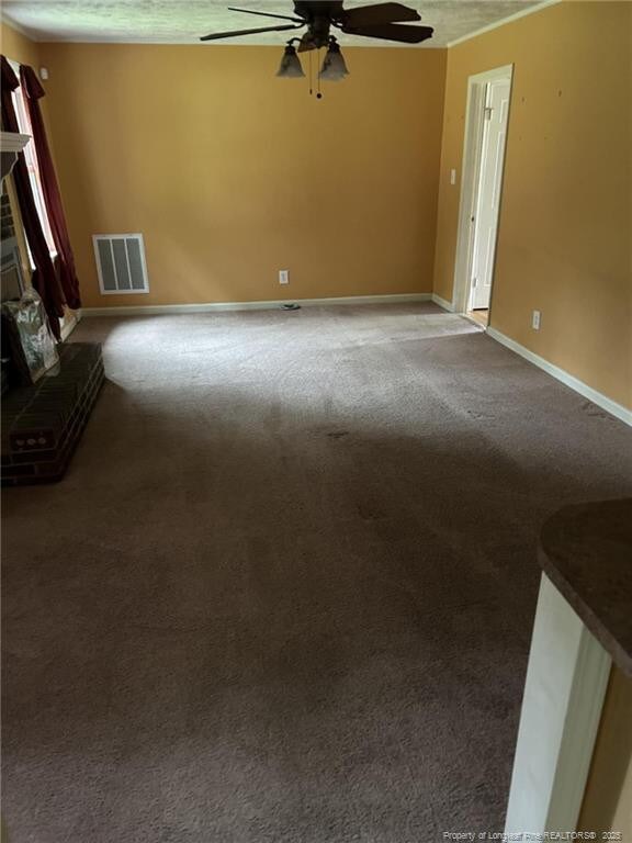 1519 Palmer Dr, Fayetteville, NC 28303 - unfurnished living room with ceiling fan, a brick fireplace, carpet flooring, and a textured ceiling