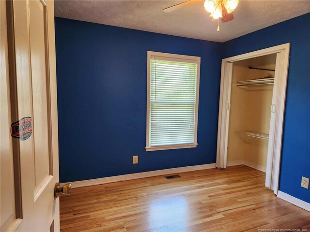 1519 Palmer Dr, Fayetteville, NC 28303 - unfurnished bedroom with wood finished floors, a closet, a textured ceiling, and a ceiling fan