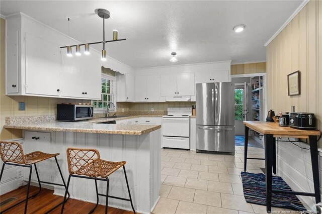 2613 N Edgewater Dr, Fayetteville, NC 28303 - kitchen with appliances with stainless steel finishes, a peninsula, crown molding, white cabinets, and under cabinet range hood