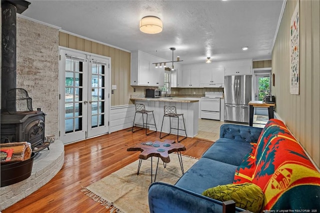 2613 N Edgewater Dr, Fayetteville, NC 28303 - living area with crown molding, a wood stove, light wood-style flooring, and a textured ceiling