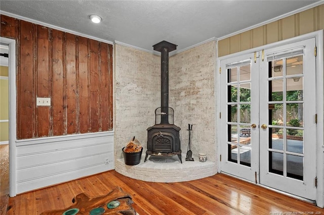 2613 N Edgewater Dr, Fayetteville, NC 28303 - unfurnished living room featuring a wood stove, wood finished floors, crown molding, and wood walls