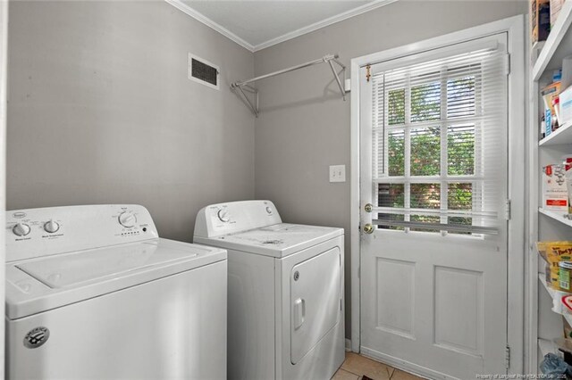 2613 N Edgewater Dr, Fayetteville, NC 28303 - laundry room featuring washing machine and clothes dryer, ornamental molding, and light tile patterned floors