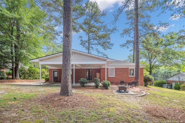 2613 N Edgewater Dr, Fayetteville, NC 28303 - back of house with an outdoor fire pit, brick siding, and an attached carport