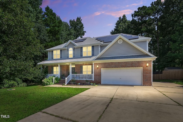 1205 Magnolia Hill Rd, Garner, NC 27529 - traditional home with a porch, brick siding, concrete driveway, a garage, and roof mounted solar panels