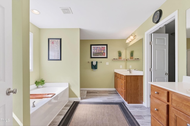 1205 Magnolia Hill Rd, Garner, NC 27529 - full bath featuring two vanities, wood finished floors, and a garden tub