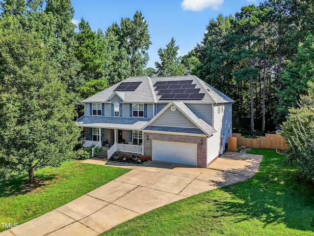1205 Magnolia Hill Rd, Garner, NC 27529 - colonial inspired home featuring a porch, concrete driveway, roof mounted solar panels, brick siding, and a garage