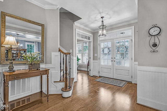 101 Tatum Ct, Holly Springs, NC 27540 - entryway featuring a chandelier, wainscoting, crown molding, wood finished floors, and a decorative wall
