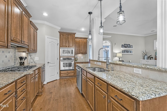 101 Tatum Ct, Holly Springs, NC 27540 - kitchen with backsplash, appliances with stainless steel finishes, crown molding, brown cabinetry, and wood finished floors