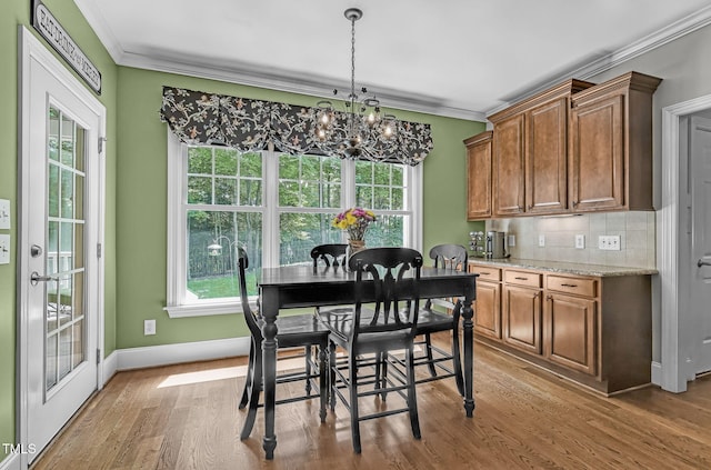 101 Tatum Ct, Holly Springs, NC 27540 - dining space with ornamental molding, a chandelier, and light wood-type flooring