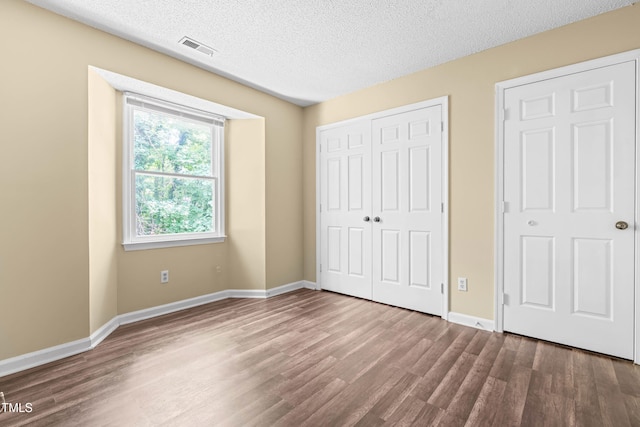 1320 Park Glen Dr Unit 204, Raleigh, NC 27610 - unfurnished bedroom featuring dark wood finished floors, a closet, and a textured ceiling