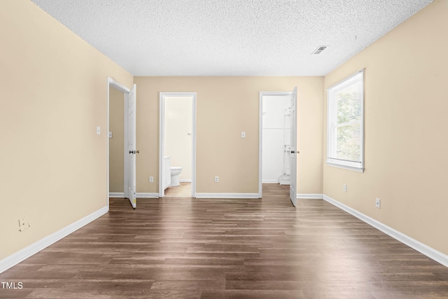 1320 Park Glen Dr Unit 204, Raleigh, NC 27610 - unfurnished bedroom featuring a textured ceiling, dark wood finished floors, a walk in closet, ensuite bath, and a closet