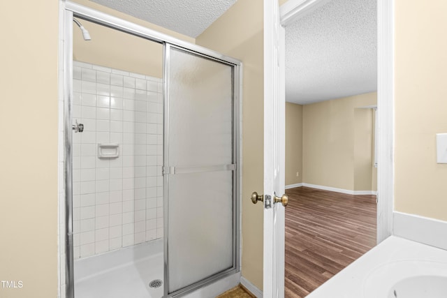 1320 Park Glen Dr Unit 204, Raleigh, NC 27610 - bathroom with a textured ceiling, a stall shower, and wood finished floors