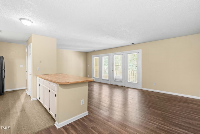 1320 Park Glen Dr Unit 204, Raleigh, NC 27610 - kitchen with white cabinetry, freestanding refrigerator, dark wood-style floors, open floor plan, and a textured ceiling