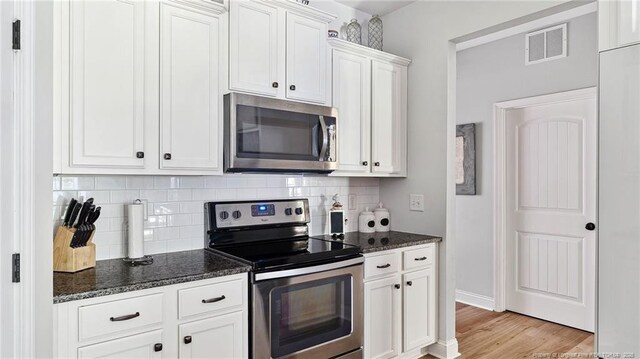 75 Bynum Ct, Carthage, NC 28327 - kitchen featuring stainless steel appliances, decorative backsplash, dark stone counters, and white cabinets