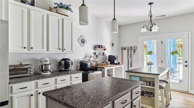 75 Bynum Ct, Carthage, NC 28327 - kitchen featuring a kitchen island, backsplash, and white cabinets